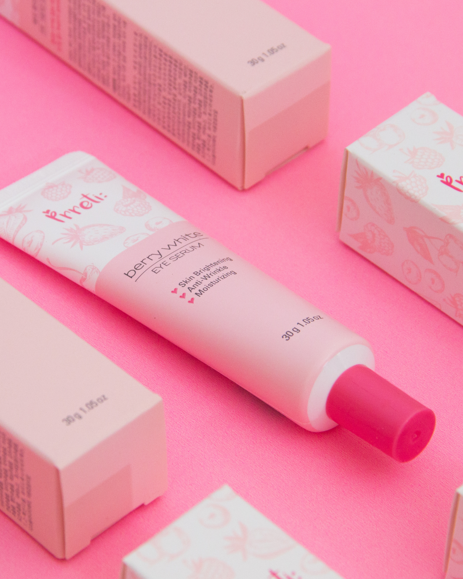 Editorial flat-lay of pink beauty product packaging on a bright pink background